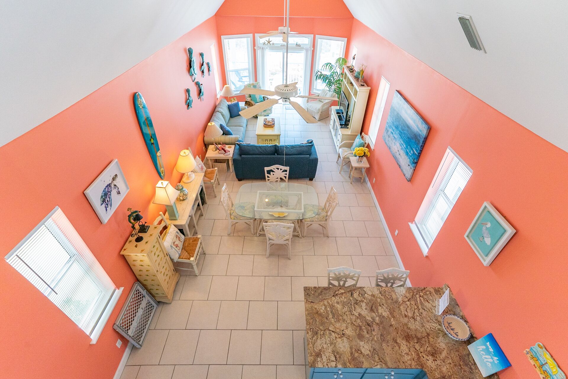 Un salon lumineux et spacieux avec un plafond haut, un espace salon central comprenant un canapé et des fauteuils, ainsi qu'une table à manger.