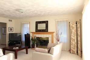 TV connectée, cheminée, livres, chaîne hi-fi