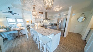 A spacious kitchen with a large island, white cabinetry, and modern appliances. - 3BR/2BA 1st Tier, Timeless Beauty w/ Easy Beach Access & Clubhouse w/ Pool! (St. George Island)