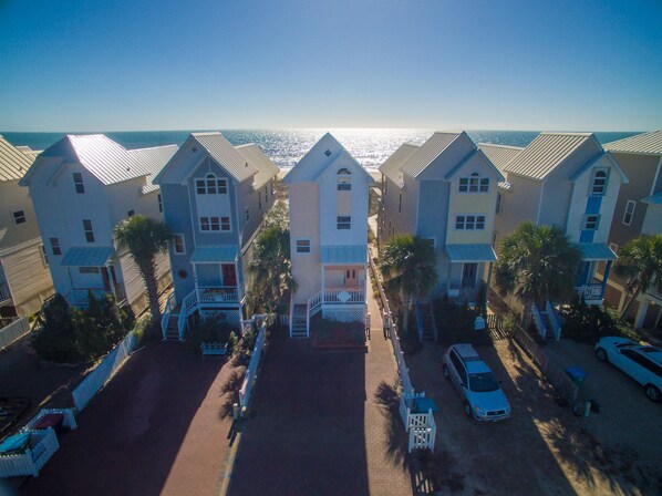 A row of beachfront houses with a paved driveway and parked cars. - Pet Friendly, 3BR/3BA, Easy Walking Distance to Shops (St. George Island)