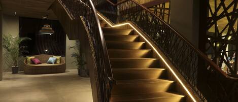 A staircase with wooden steps and a metal railing, leading to a lower level.