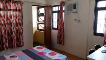Cozy retreat with a comfortable bed, wooden floor, and a table for two.