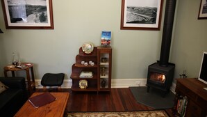 Una sala de estar acogedora con chimenea, estantería, una mesa de centro y una alfombra.