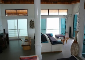 A spacious living area with a large sofa, a coffee table, and a decorative vase.