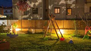 A well-maintained backyard with a swing set, a small tree, and a play area.