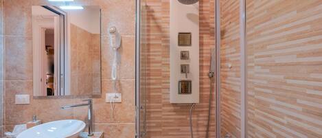 A modern bathroom with a glass-enclosed shower, a built-in sink, and a vanity with a mirror.