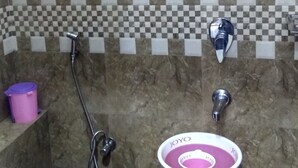 A bathroom with a toilet, a sink, and a shower. - Hotel Plaza Mumbai (Mumbai)