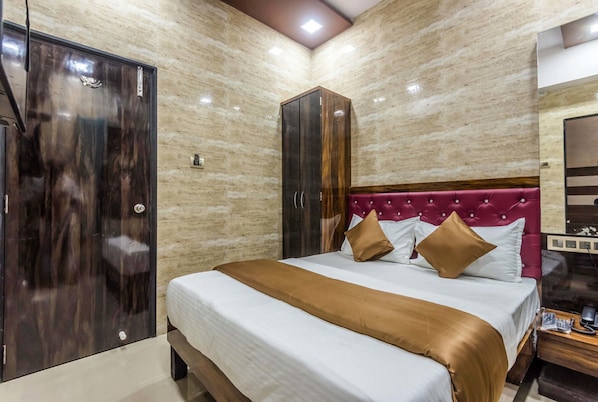 A bedroom with a bed, a wardrobe, and a nightstand.