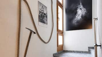 Una escalera con una cuerda en la pared, una fotografía enmarco y una imagen en blanco y negro.