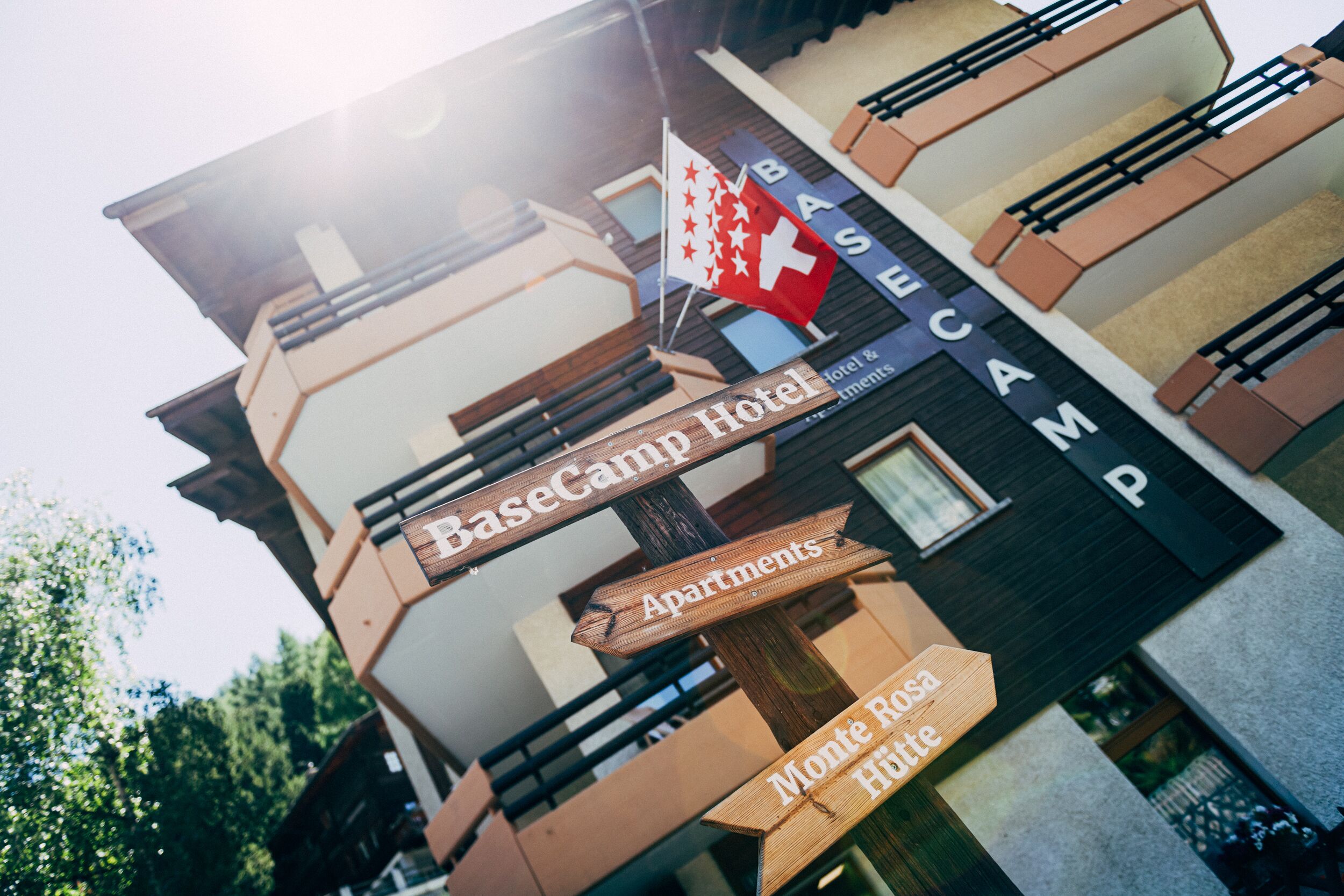 Un hotel con carteles que indican BaseCamp Hotel, Apartments y Hotel Monte Rosa.