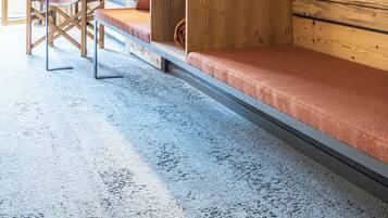 A compact room with a wooden wall, a bench, a table, and a chair.