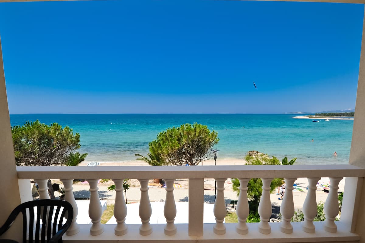 A balcony with a view of a beach and ocean.