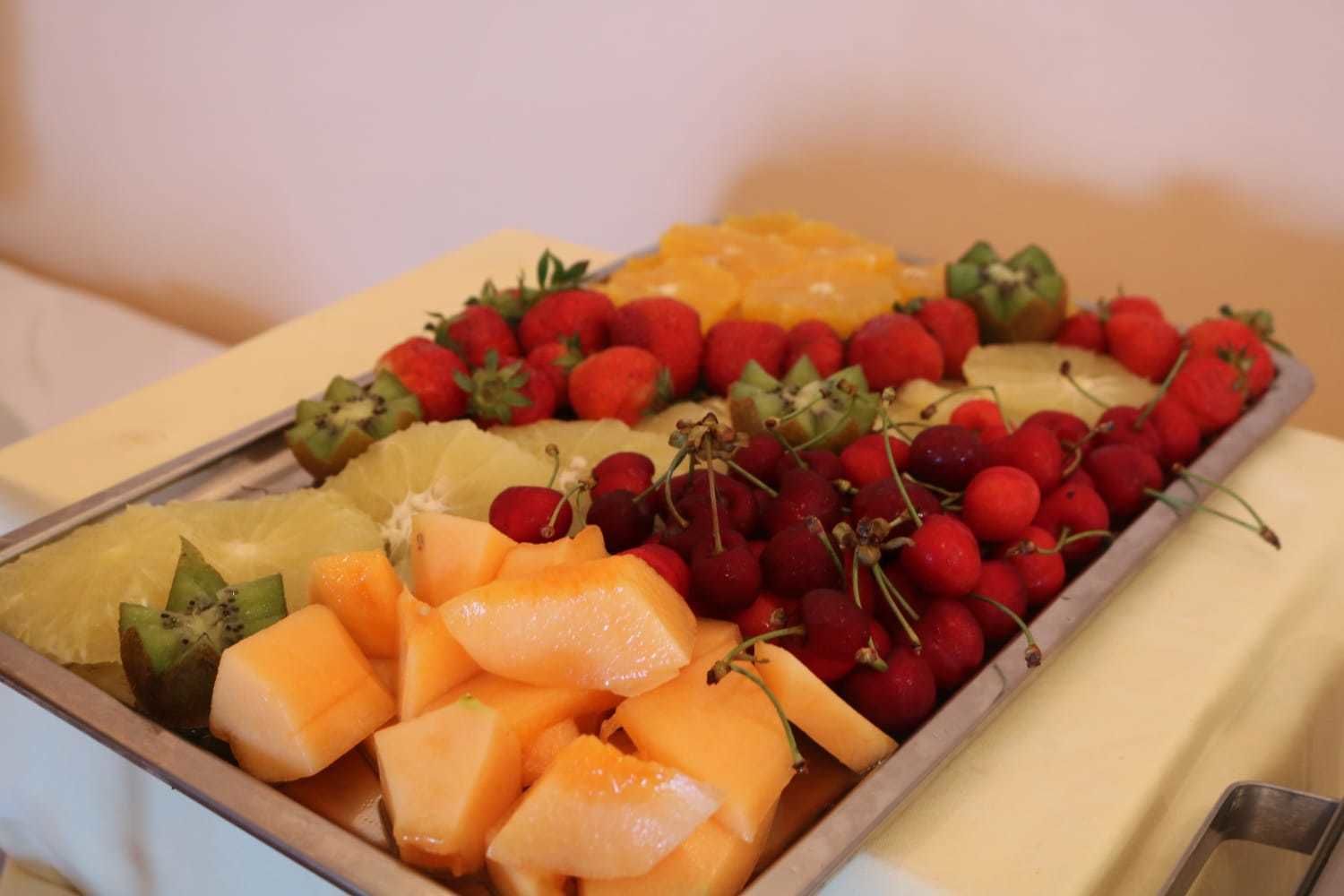 Eine Auswahl an Früchten, darunter Erdbeeren, Kirschen, Ananas und Cantaloupe-Melone.