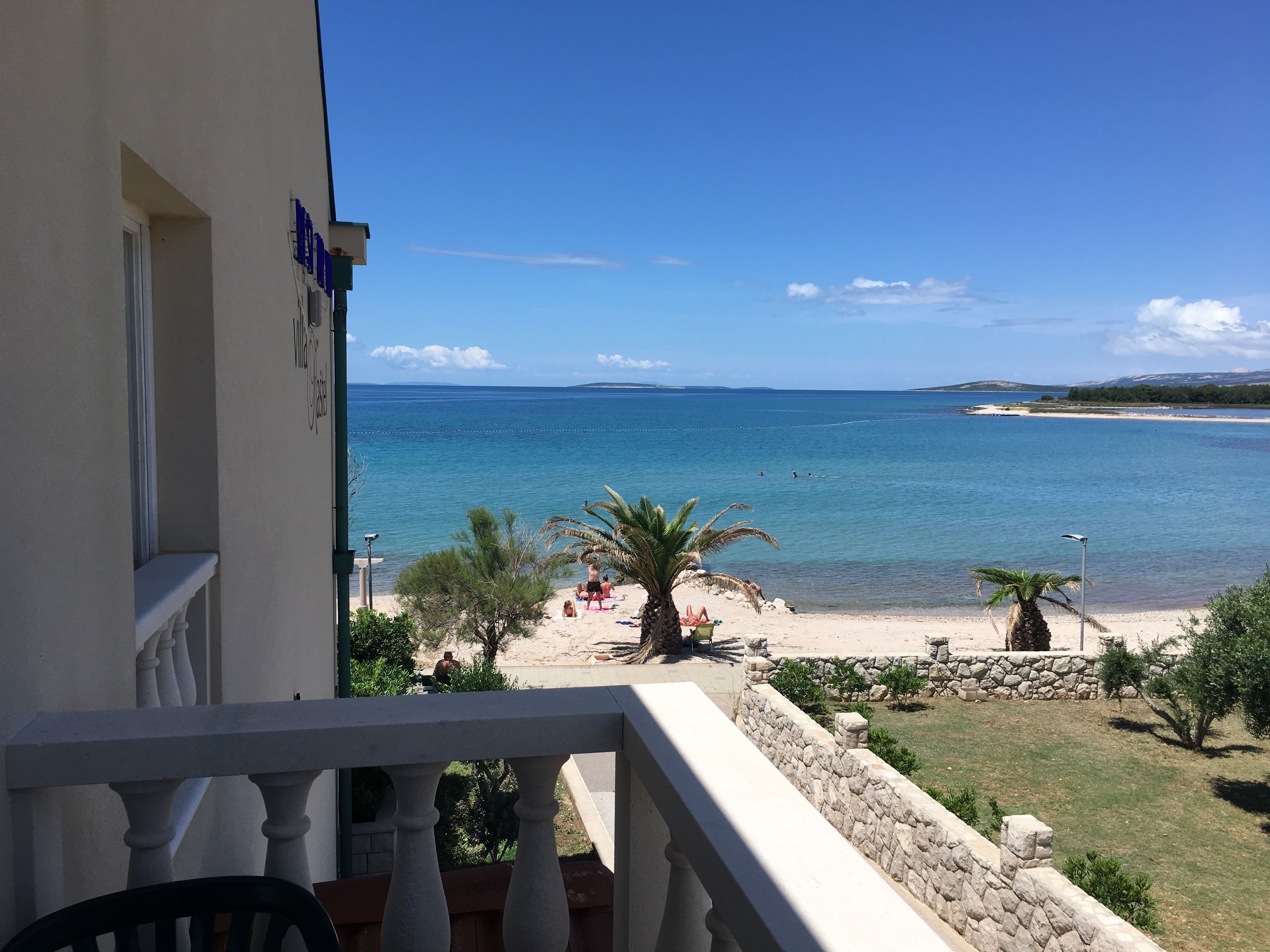 Un balcon avec vue sur une plage et la mer.