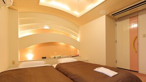 A hotel room with two beds, a minibar, and a wardrobe. - Reco Hotel Mikuni (Toyonaka)