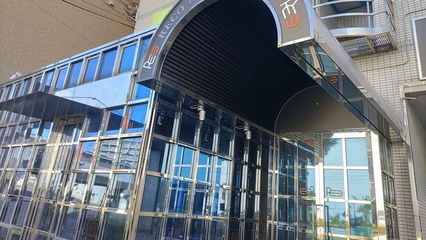 A hotel entrance with a modern glass facade, a prominent archway, and a sign reading "RECO HOTEL MIKUNI". - Reco Hotel Mikuni (Toyonaka)