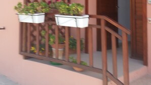 A building with a sign that reads "Casa de la Cultura" and a flag. There are potted plants on the balcony. - L'Onda Blu (Domus de Maria)