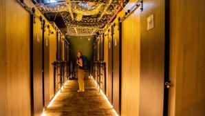 A hotel hallway with a carpeted floor, wooden doors, and a person standing in the center. - Cinema Hostel Jerusalem (Jerusalem)