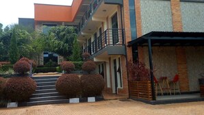 A modern building with a brick facade, multiple balconies, and a covered outdoor seating area. - Shami Luxury Apart (Kigali)