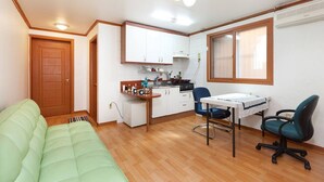 A compact living space with a kitchenette, a dining area, and a sofa.
