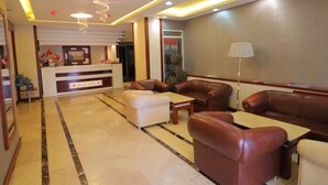 A hotel lobby with a reception desk, leather sofas, a coffee table, and a floor lamp. - Artan Hotel (Isparta)