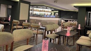 A restaurant with a bar area, multiple seating arrangements, and a modern interior design. - Artan Hotel (Isparta)