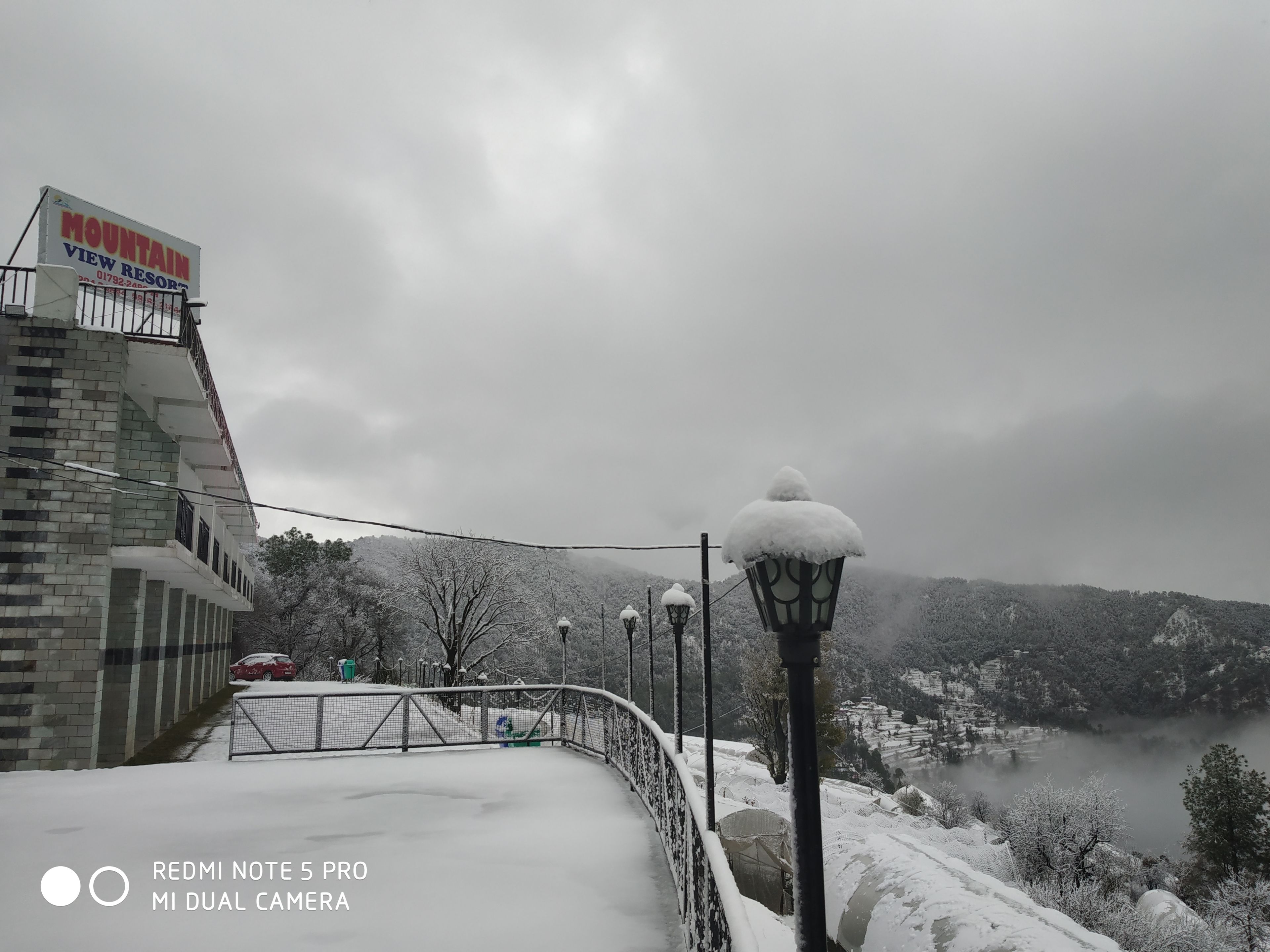 A snow-covered view of a mountain resort with a sign for 'Mountain View Resort'.