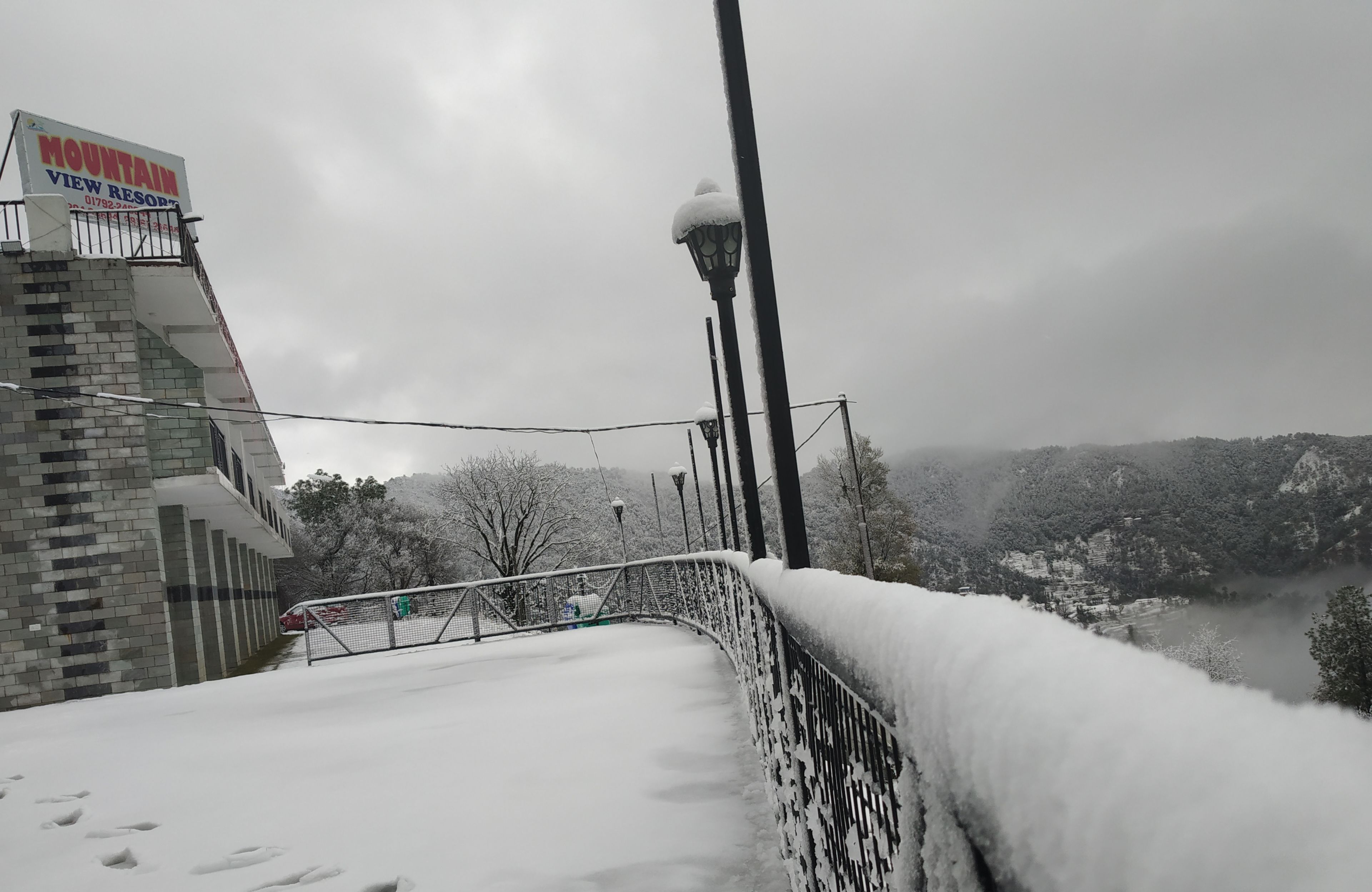 Un sendero cubierto de nieve que lleva a un edificio con un letrero que dice 'Mountain View Resort'.