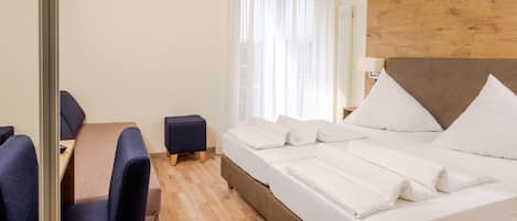 Una camera d'albergo con un letto, una scrivania e una sedia.