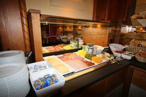 A buffet with various food items and a glass display case.