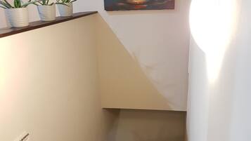 A staircase with a white wall and a painting of flowers.
