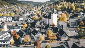 A town with a prominent church, residential buildings, and autumn foliage. - Hotel Gasthof Koch (Daaden)
