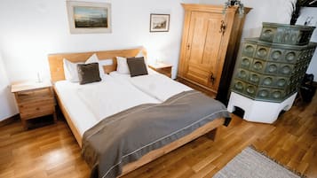 Un dormitorio con una cama de madera, una mesita de noche, un armario y un mueble decorativo.
