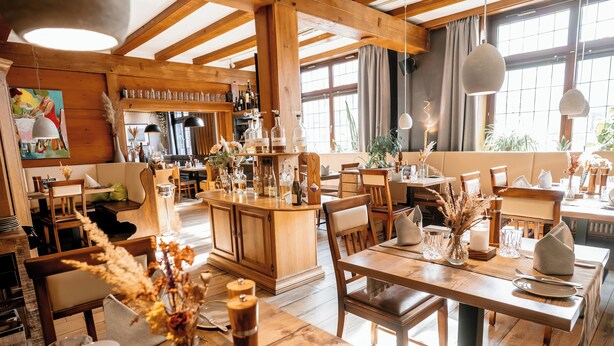 A cozy restaurant with wooden furniture, a bar area, and large windows. - Hotel Gasthof Koch (Daaden)