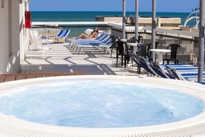 A pool area with a hot tub, lounge chairs, and a view of the ocean. - Hotel Brig (Cattolica)