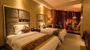 Une chambre d’hôtel avec deux lits, un coin salon avec une table et des chaises, et une vue sur l’intérieur de la pièce.