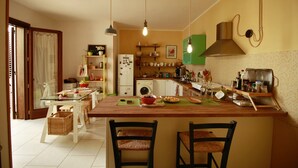 Une cuisine dotée d’un îlot central, d’un lave-linge et de divers ustensiles de cuisine.