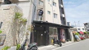 A multi-story building with a ground-level commercial space, a visible entrance, and a parked motorcycle. - Especially Chef's Home B&B (Hualien City)
