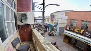 A narrow alleyway with a small seating area, a 7-Eleven store, and a building with a sign reading "Sunny". - Danke Hostel (Liuqiu)