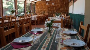 A dining area with wooden tables and chairs, set with plates, glasses, and cutlery. - Agriturismo Cascina Madonnina (Pregnana Milanese)