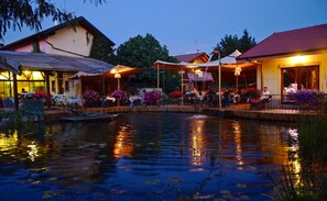 A riverside restaurant with outdoor seating and a pond. - Agriturismo Cascina Madonnina (Pregnana Milanese)