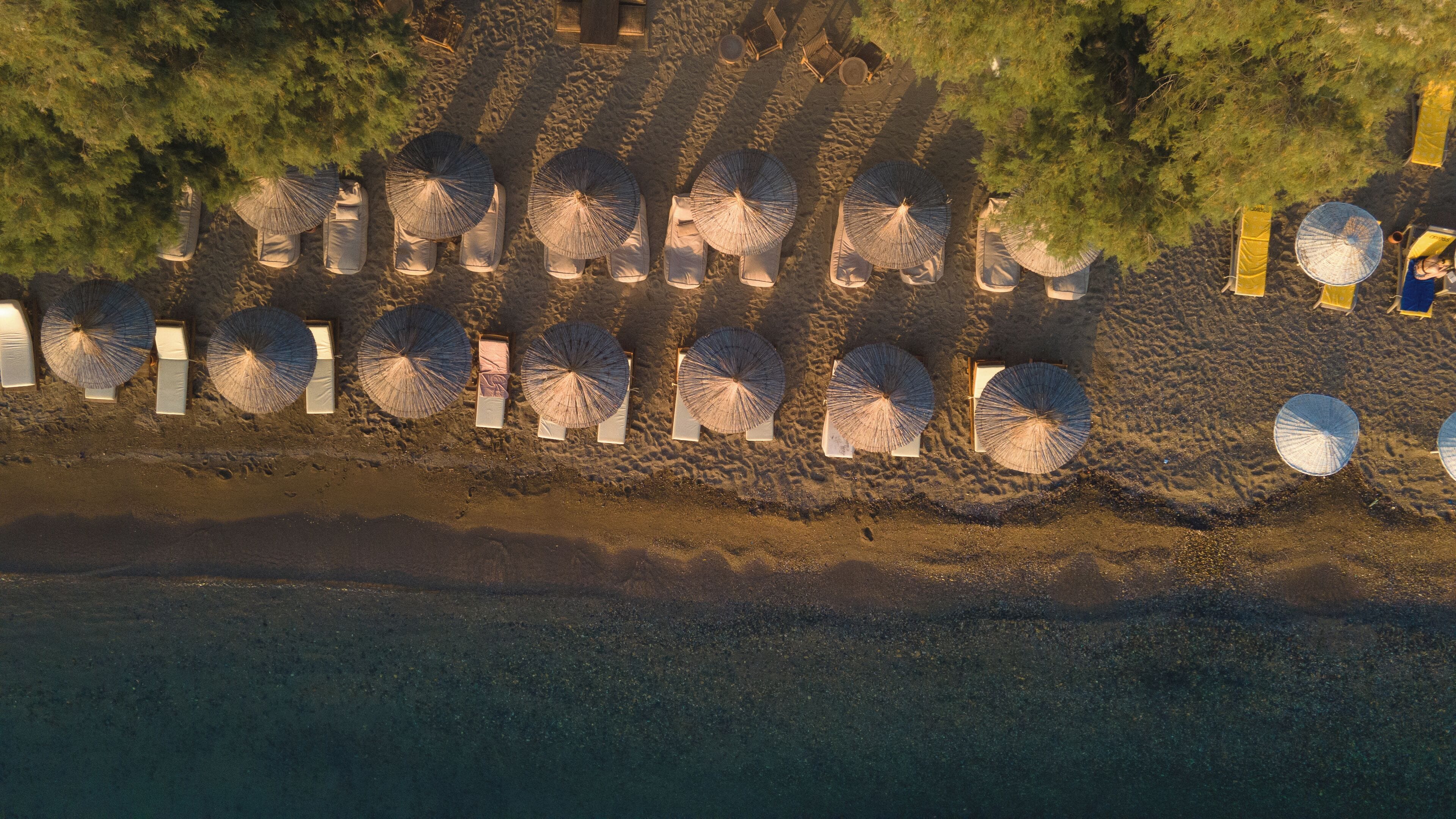 Een privéstrand, ligstoelen aan het strand, parasols