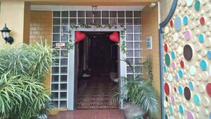 A hotel entrance with a 'Welcome' sign, a heart-shaped decoration, and a patterned floor.