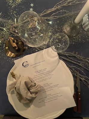 A table set with a menu, a wine glass, and a decorative bowl.