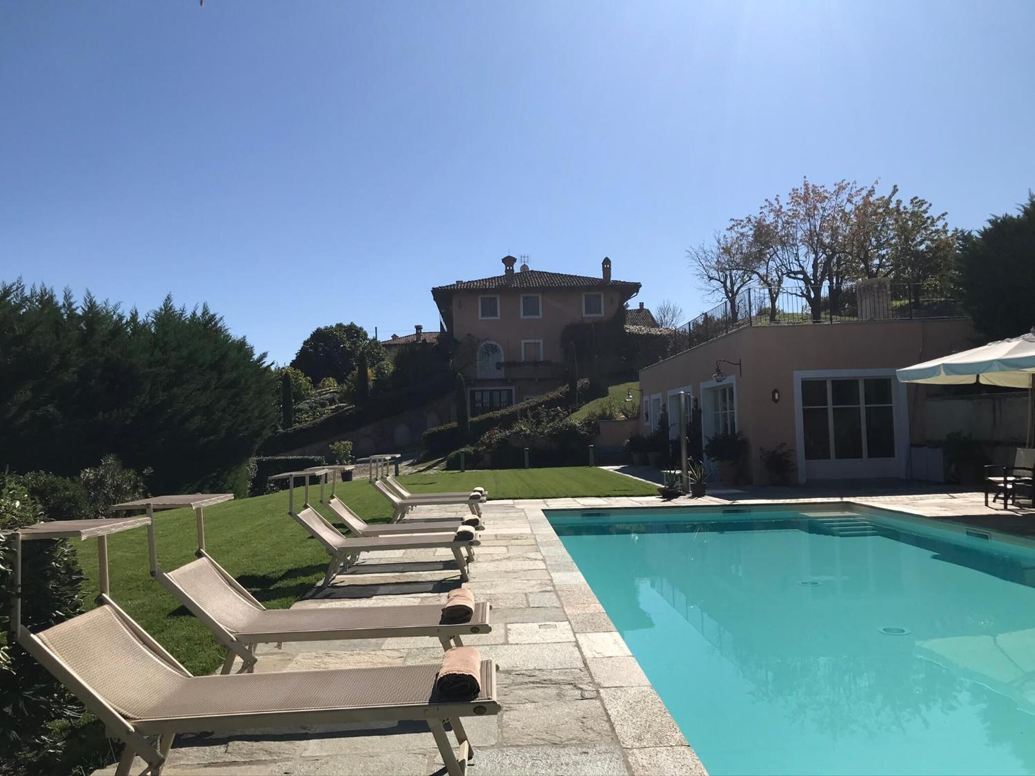 A swimming pool with lounge chairs and a building in the background.