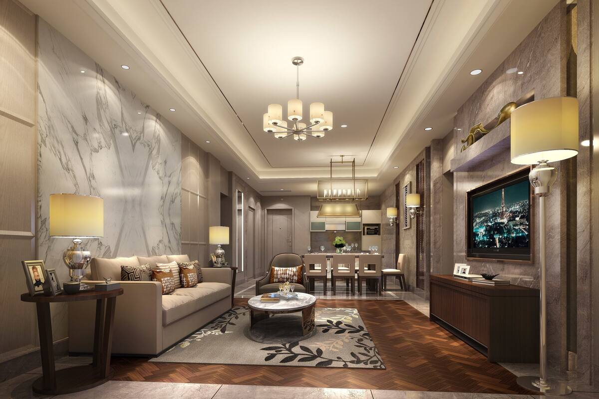 Un hall d’hôtel moderne avec un comptoir de réception en marbre, un canapé agrémenté de coussins décoratifs, une table basse et un lustre.