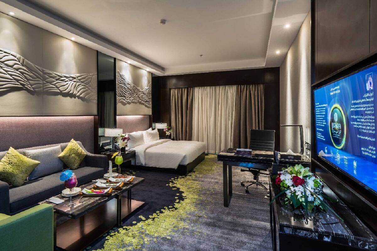 Une chambre d’hôtel moderne équipée d’un lit, d’un canapé, d’un bureau et d’une télévision.