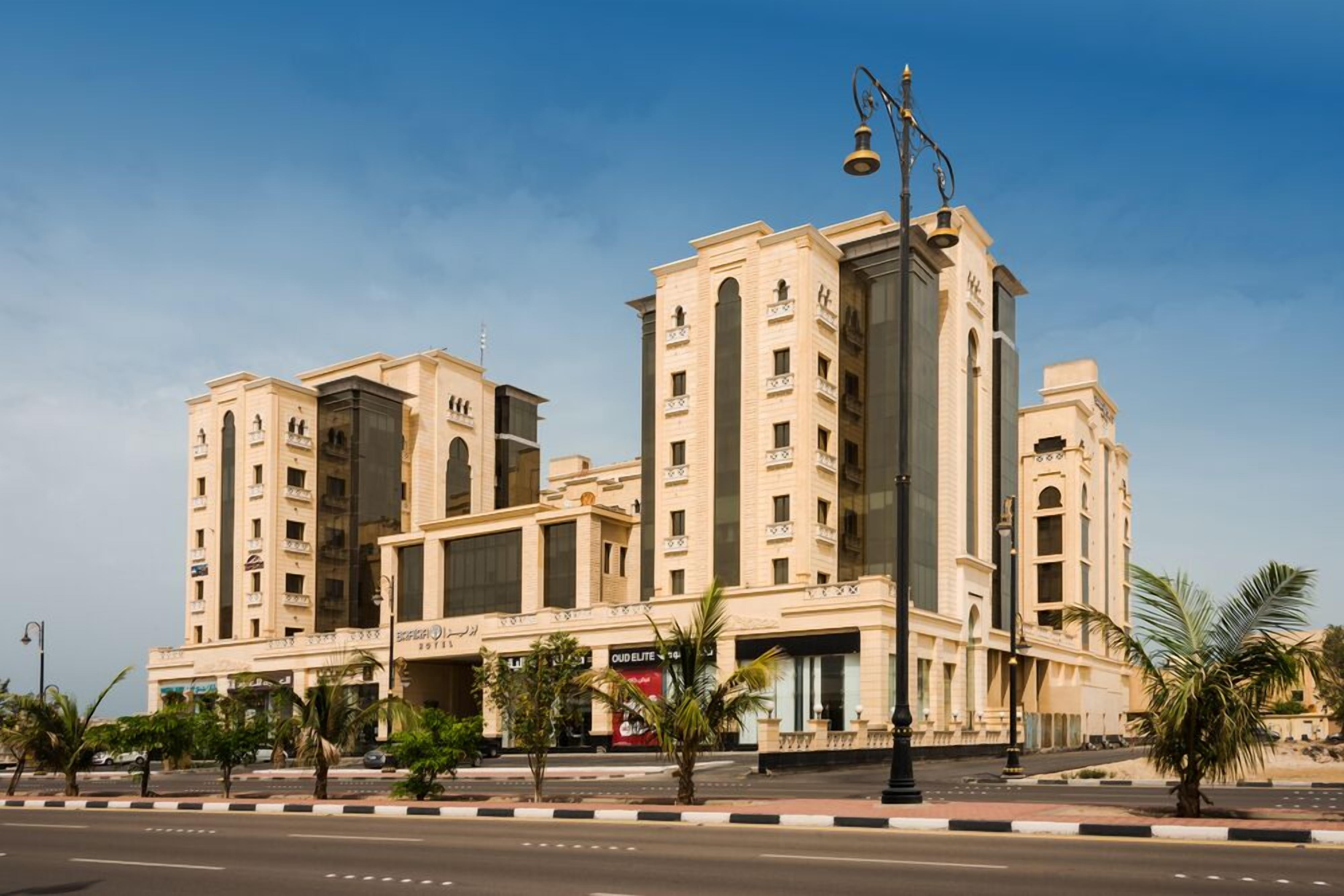 A multi-story hotel with a beige facade, large windows, and a prominent entrance.