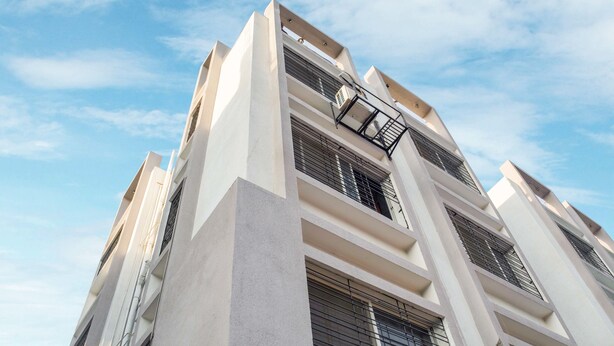 A multi-story building with a modern architectural design, featuring large windows with metal grilles and a fire escape on the exterior. - Treebo Naunidh Suites (Pune)