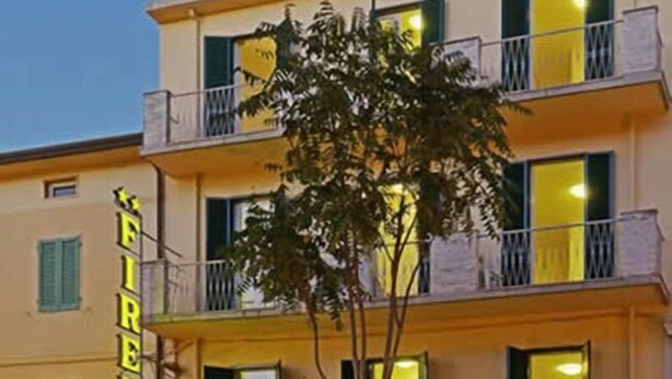 Un hotel de varios pisos con balcones y un letrero que dice "FIRENZE".